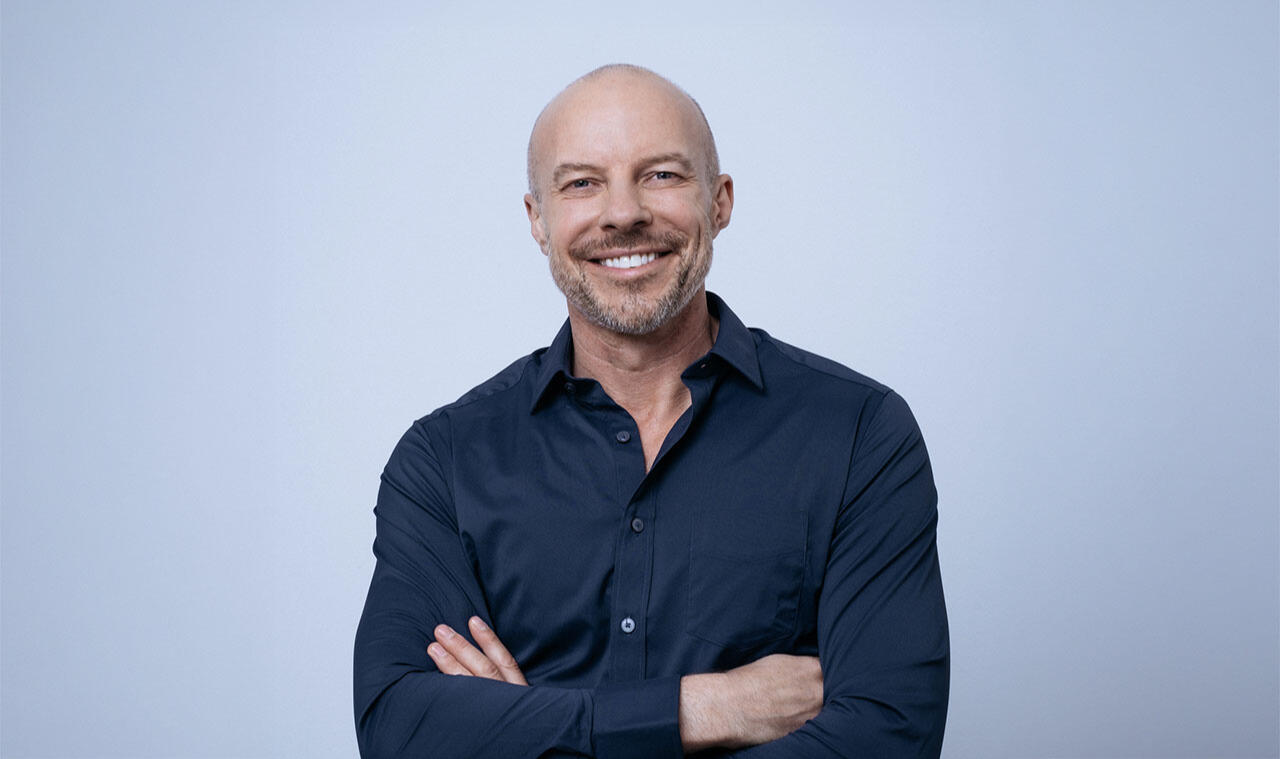 Presenter Gary Williams looking towards the camera in a blue shirt